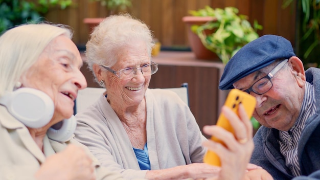 Foto drei ältere menschen aus einem altersheim benutzen das telefon