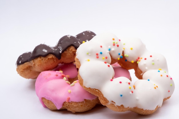 Drei Arten von Donuts haben Schokolade, weiße Creme, rosa Creme auf weißem Hintergrund.