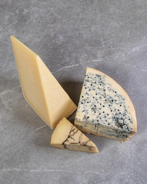 Drei Arten von Käse Parmesan und Gorgonzola Alter gereifter Käse Blauschimmelkäse Gourmet Vorspeise italienische traditionelle Küche auf grauem Marmor