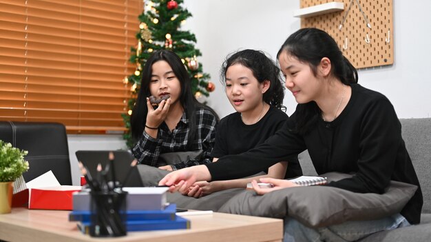 Drei asiatische Kinder, die zusammen zu Hause Online-Klasse mit persönlichem Tutor auf Computer-Laptop lernen.