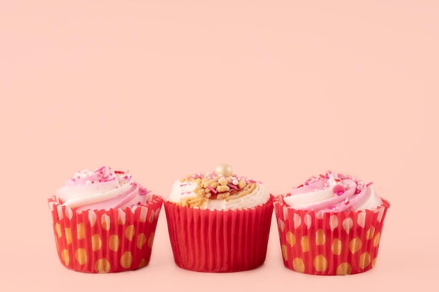 Drei Beerenmuffins in roten Verpackungen auf einem rosa Hintergrund hochwertige Fotos für Kalender und Karten