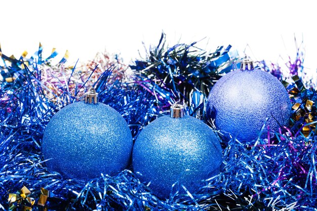 Drei blaue Weihnachtsbälle und Lametta getrennt