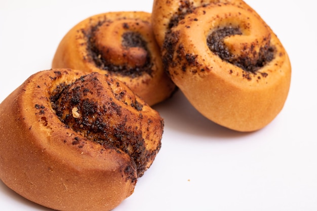 Drei Brötchen mit Mohn auf weißem Hintergrund