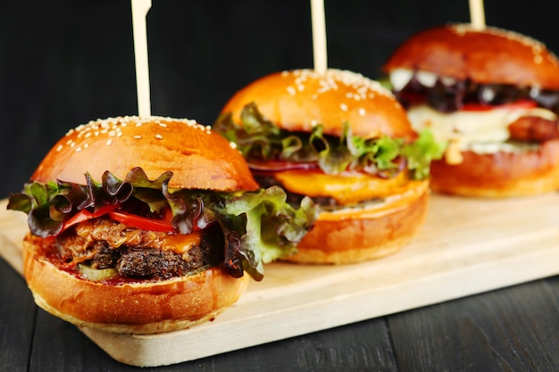 Drei Burger auf Holz. Satz Burger auf Holzdeck Nahaufnahme.