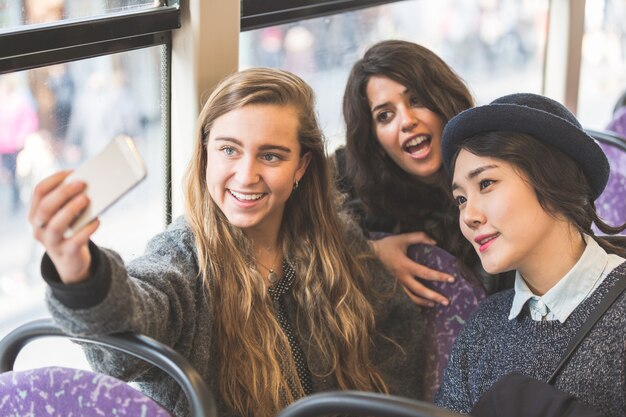 Drei, die im Bus ein Selfie machen