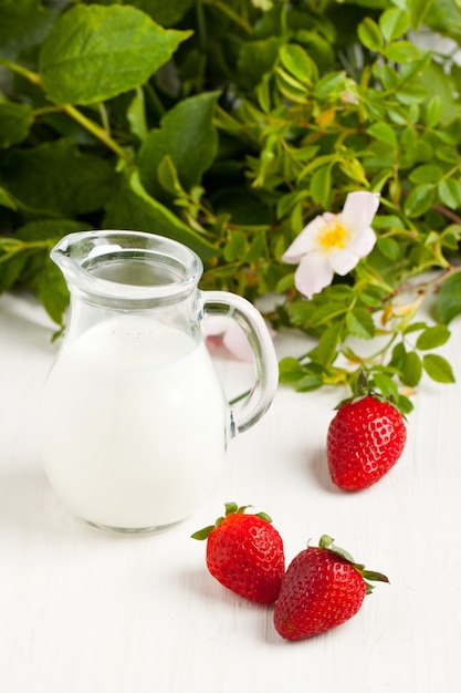 Drei Erdbeeren mit Milch