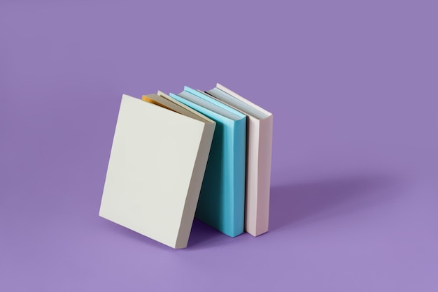 Drei farbenfrohe Bücher auf einem pastellvioletten Hintergrund mit weichem Schattenkopierraum