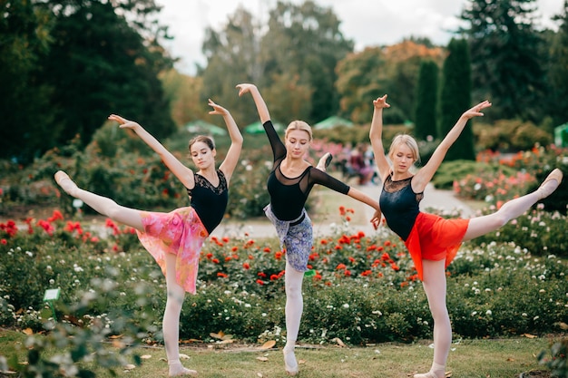 Drei flexible Balletttänzer balancieren im Park