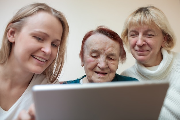 Foto drei frauen, die eine intelligente tablette verwenden