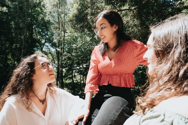 Drei Frauen haben einen lustigen Tag im Wald, multikulturelles und Freundschaftskonzept, Pflege und Liebe