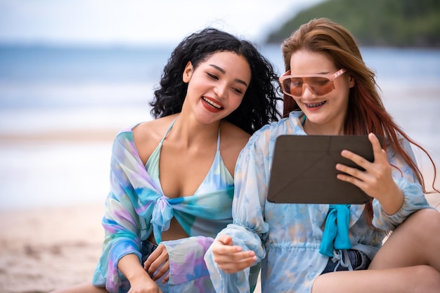 Drei Frauen LGBT-Beziehung Sommerurlaub am Strand.