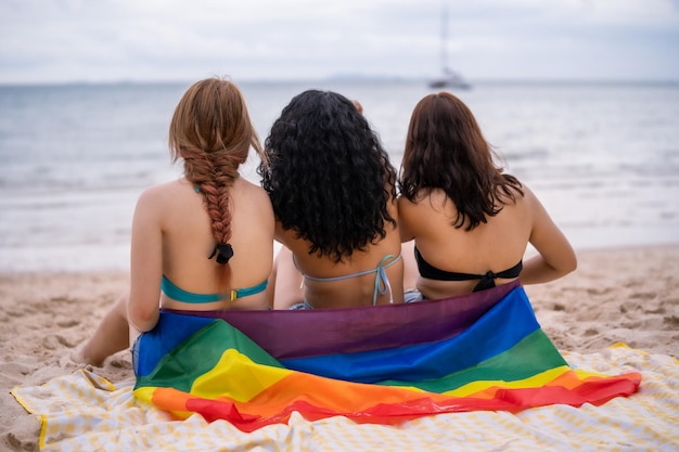 Drei Frauen LGBT-Beziehung Sommerurlaub am Strand.