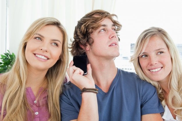 Drei Freunde, die auf ein Telefongespräch hören