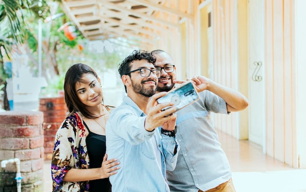 Drei Freunde, die draußen ein Selfie machen Drei lächelnde Freunde, die ein Selfie auf der Straße machen Vorderansicht von drei fröhlichen Freunden, die ein Selfie auf der Straße machen Friends selfie concept