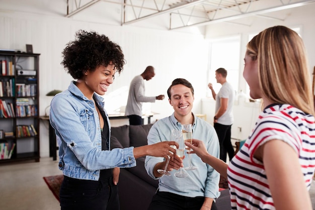 Drei Freunde in einer Loft-Wohnung stoßen aus nächster Nähe an