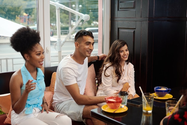 Drei Freunde unterhalten sich in einem Café. Freundschaft, Kommunikation, Quarantäne-Endkonzept.