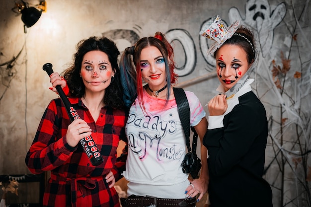 Drei Freundinnen mit gruseligem Make-up, die zusammen Halloween-Feiertage feiern