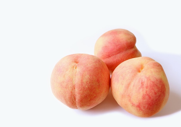 Drei frische reife Pfirsiche isoliert auf weißem Hintergrund