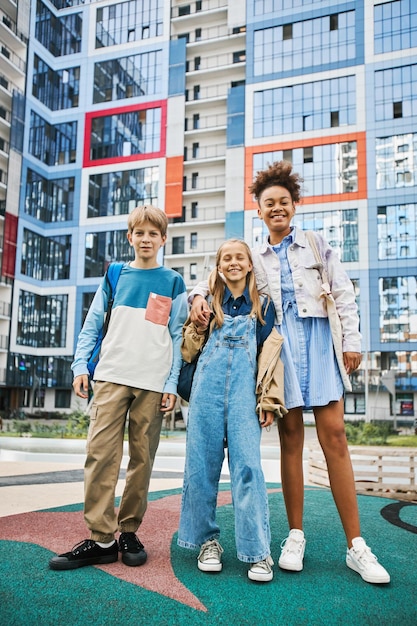 Drei fröhliche und freundliche interkulturelle Schulkinder in Freizeitkleidung