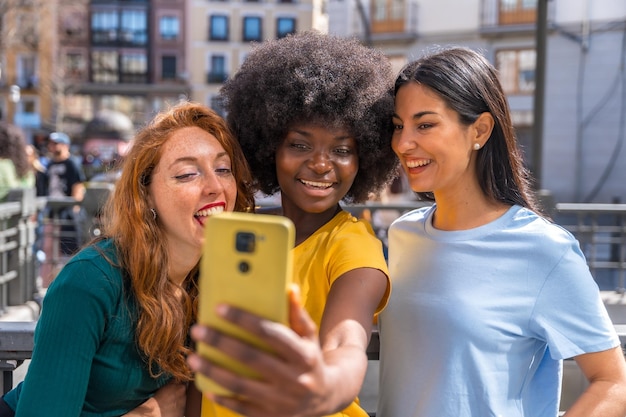 Drei gemischtrassige junge Frauen machen ein Selfie im Feminismus des Stadtfreundschaftskonzepts