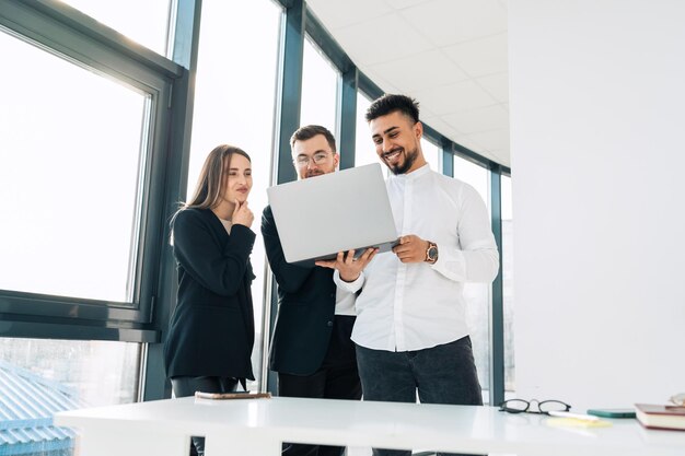 Drei Geschäftsleute mit Laptop im Büro