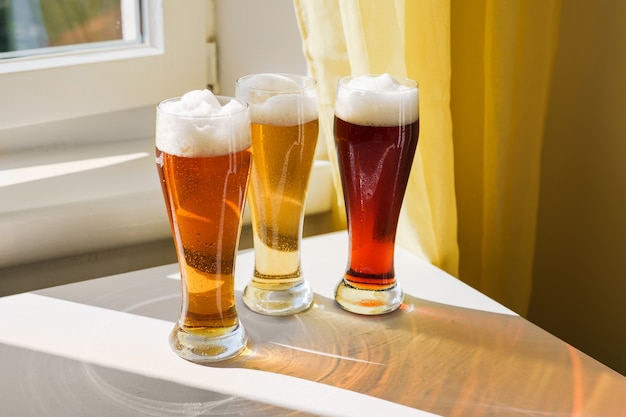 Drei Gläser mit verschiedenen Biersorten auf dem Tisch