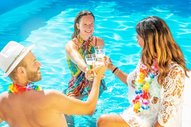 Drei glückliche Freunde feiern in einem Schwimmbad