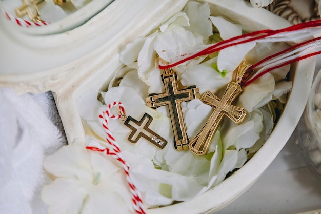 Drei goldene kleine Taufkreuze während des Taufrituals in der armenischen Kirche Nahaufnahme von goldenen Kreuzen