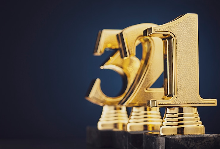 Foto drei goldene trophäen vor blau