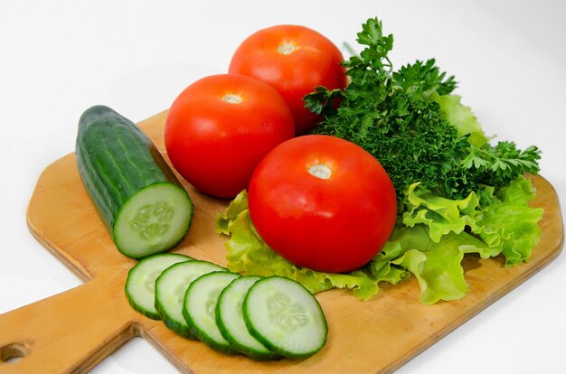 Drei große Tomaten Grüns Gurke Chopped Ring Holzbrett Gesunde Ernährung Konzept Vegetarismus, Keto-Diät, Paleo-Diät.