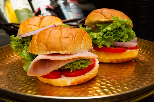 drei Hamburger auf goldenem Tablett. leckeres Frühstück