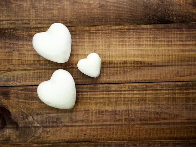 Drei Herzen auf einem dunklen hölzernen Hintergrund, Konzept des Valentinstags