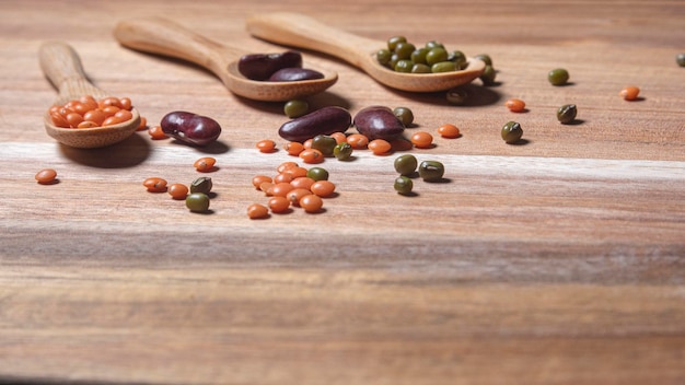 Drei Holzlöffel mit Hülsenfrüchten verschiedener Arten Bohnen, rote Linsen und Sojabohnen