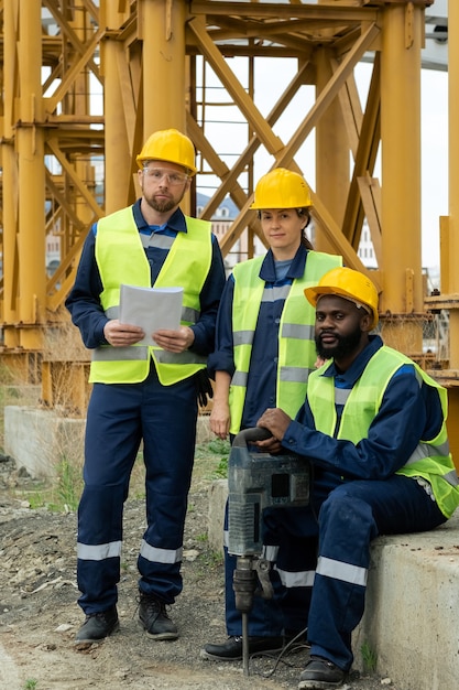 Drei interkulturelle Baumeister in Uniform auf der Baustelle