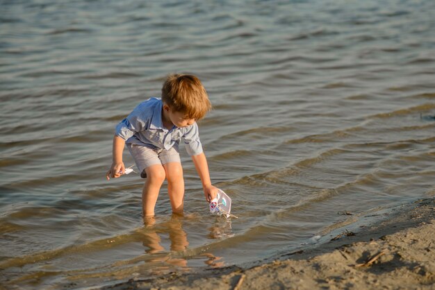 Drei Jahre alten Jungen spielen am Strand. Erholen Sie sich in den Sommerferien