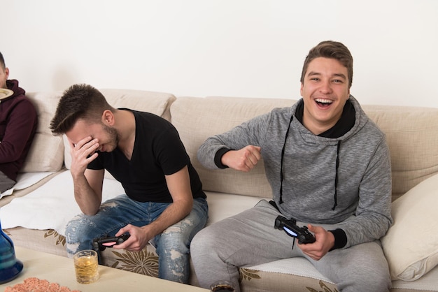 Drei junge Brüder haben eine glückliche Zeit zusammen und spielen zu Hause Videospiele