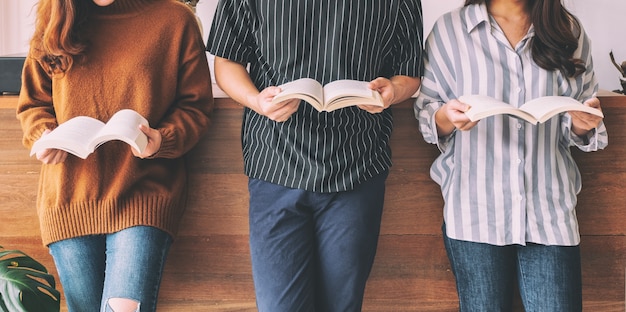 Foto drei junge leute standen und genossen es gemeinsam bücher zu lesen