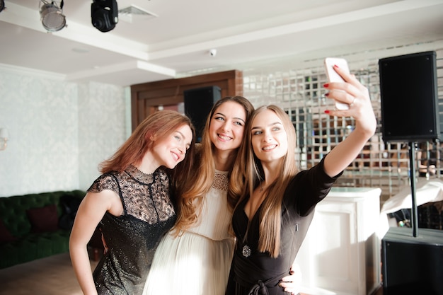 Drei junge Mädchen machen Selfie-Foto in einem Restaurant