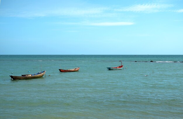 Drei kleine Fischerboote auf dem blauen Meer und dem klaren Himmel