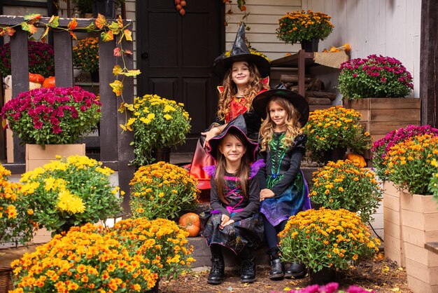 Drei Mädchenschwestern in Hexenkostümen haben Spaß beim Feiern von Halloween