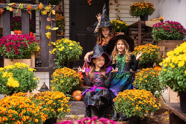 Drei Mädchenschwestern in Hexenkostümen haben Spaß beim Feiern von Halloween