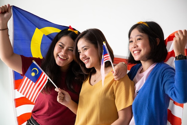 Drei malaiische Frau, die malaysische Nationalflagge hält