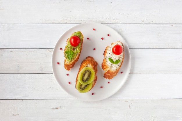 Drei Mini-Sandwiches auf einem Teller auf Holzuntergrund