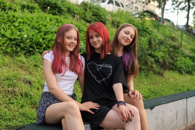 Drei modische Freunde eines Teenagers der Generation Z entspannen sich nach der Schule und haben Spaß