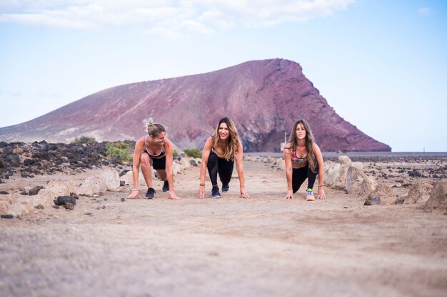 Drei nette, schöne junge Mädchen, die sich vorbereiten und bereit sind, für Outdoor-Freizeitaktivitäten Sport und Körper zu laufen. Bleiben Sie gesund mit Fitness und Übungen. Berg d