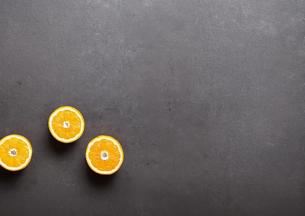 Drei Orangen auf dunklem Hintergrund mit weißem Fleck.