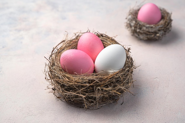 Drei Ostereier in einem Nest auf hellem Hintergrund Ostern Hintergrund Seitenansicht Großansicht