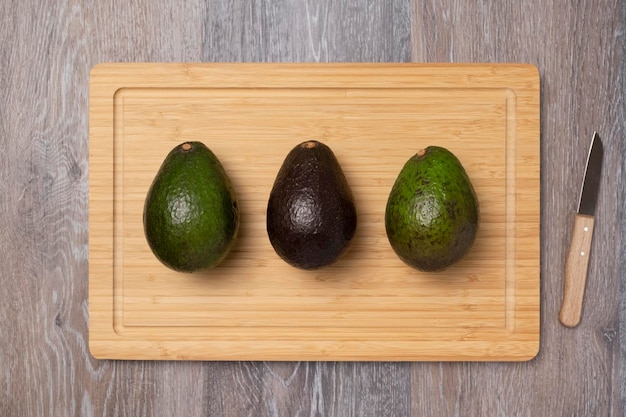 Foto drei reife haas-avocados auf schneidebrett