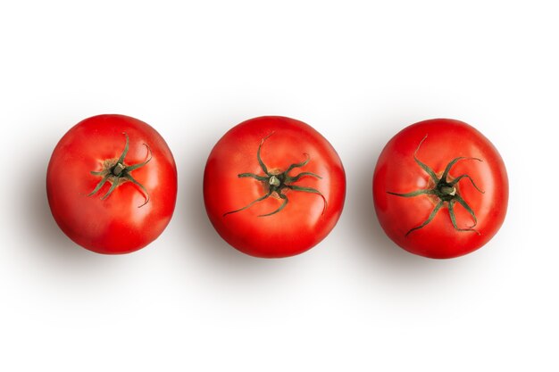 Drei reife rote Tomaten in Folge isoliert auf weißem Hintergrund. Rohes Gemüse. Flache Lay-Ansicht. Nahaufnahme