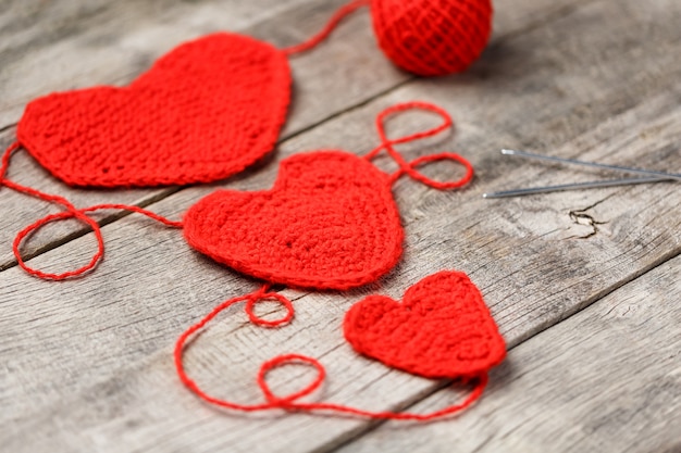 Drei rote gestrickte Herzen, Liebe und Familie symbolisierend. Familienbeziehung, Bindungen.